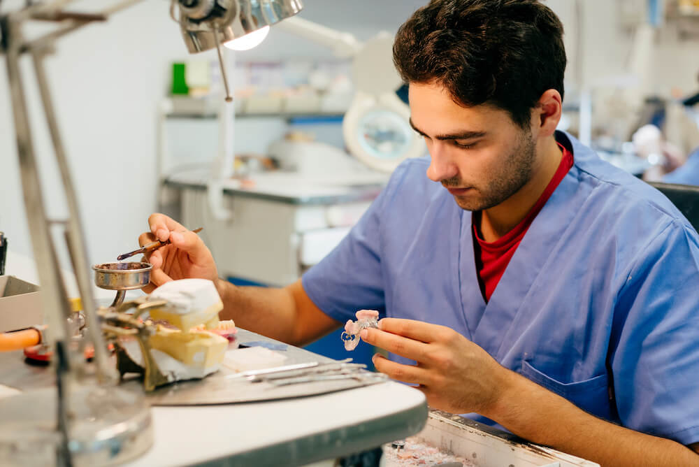 Prosthodontist finishing dentures for a patient