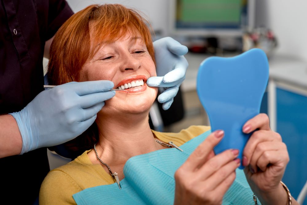 A senior woman receiving a dental examination after her dental implant procedure.