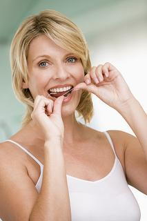Woman flossing teeth