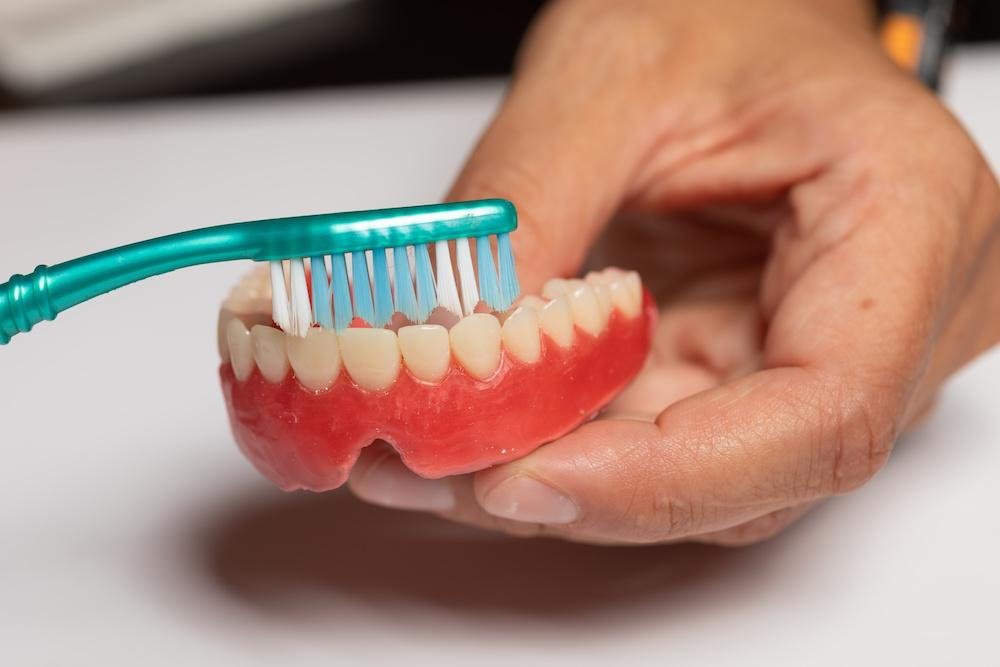 Cleaning dentures with a brush
