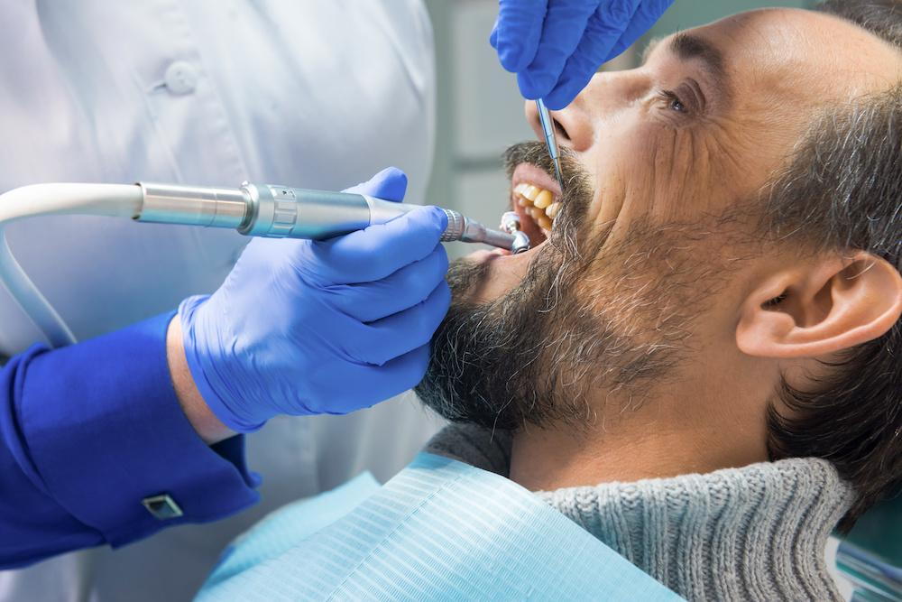 Dentist cleaning patient's teeth
