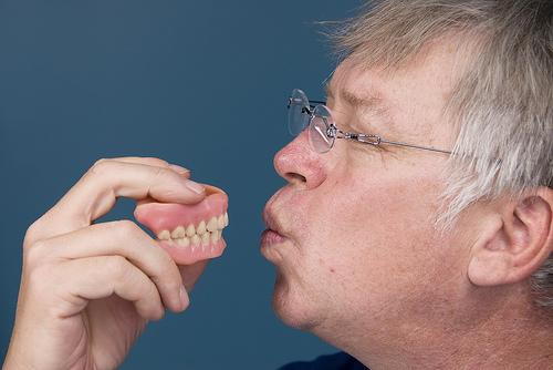 Man holding an Implant-supported dentures